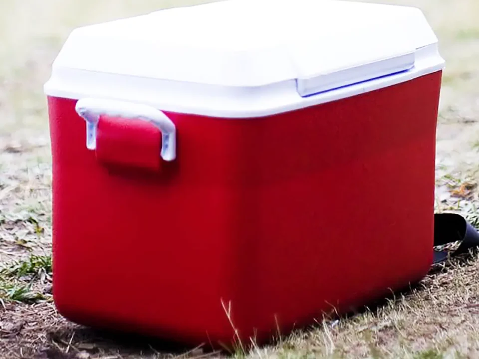 Red cooler with white lid, ready for dry ice and picnic supplies.