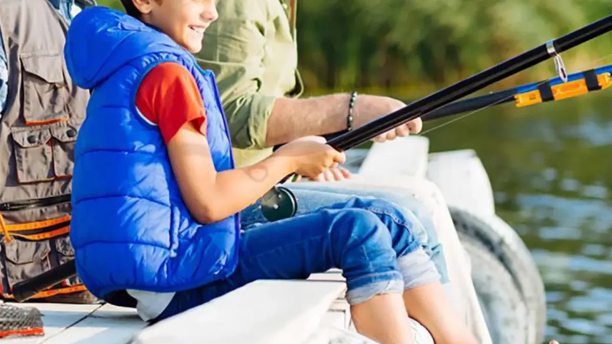 Boy and two men fishing from a dock.