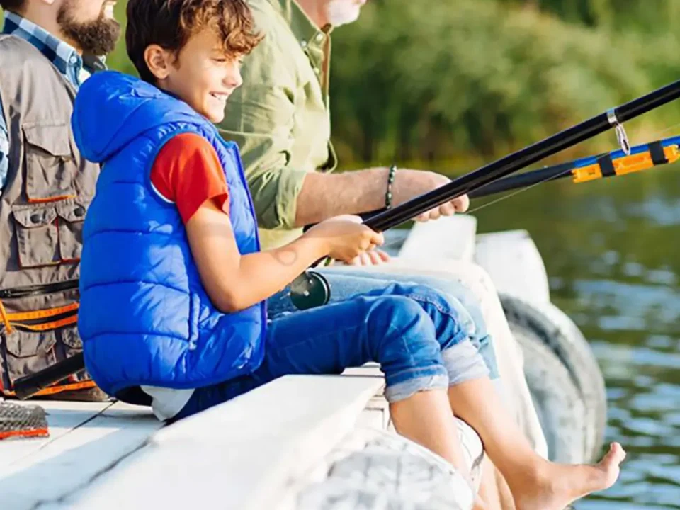 Boy and two men fishing from a dock.