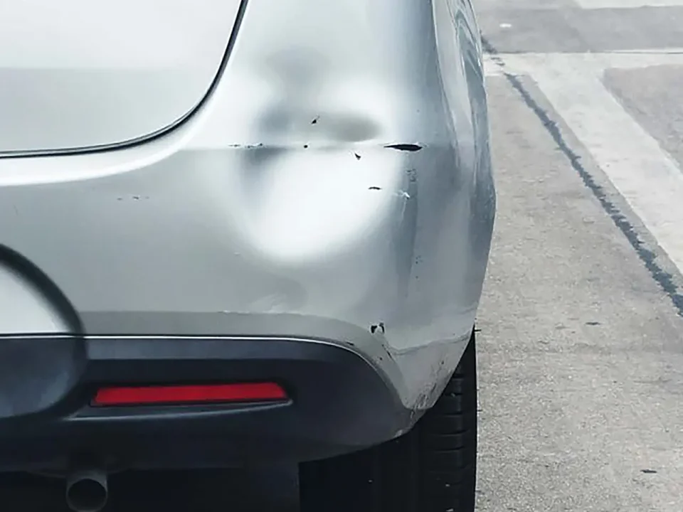 Rear bumper with significant dent damage. Dry ice dent removal may be needed.