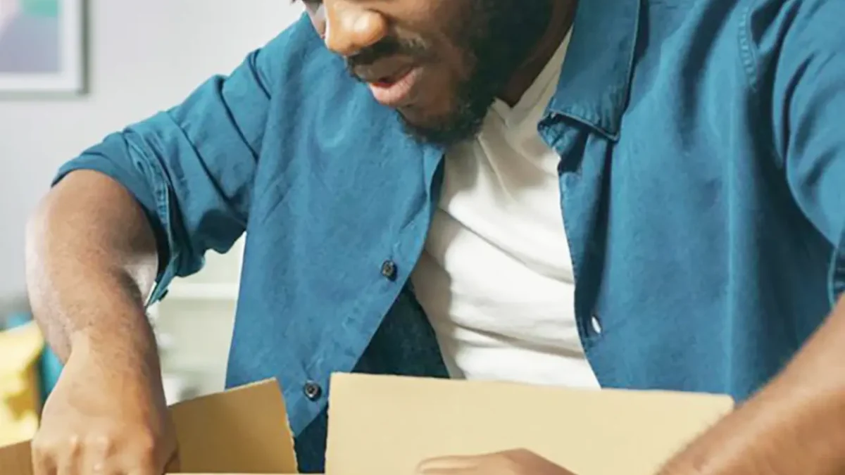 Person opening a cardboard box, possibly preparing a dry ice shipment.