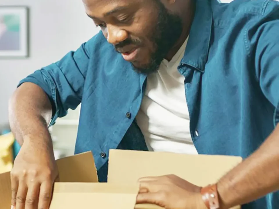 Person opening a cardboard box, possibly preparing a dry ice shipment.