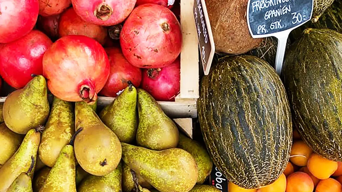 Fresh pears, pomegranates, melons, and apricots at a farmer's market. Ready for freezing?