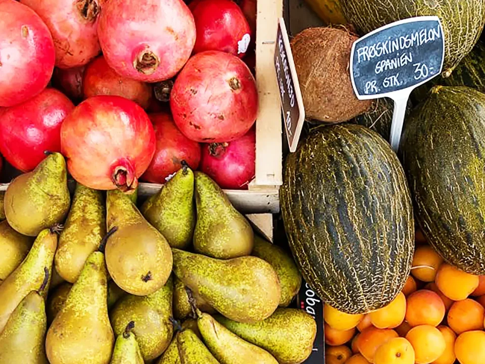 Fresh pears, pomegranates, melons, and apricots at a farmer's market. Ready for freezing?