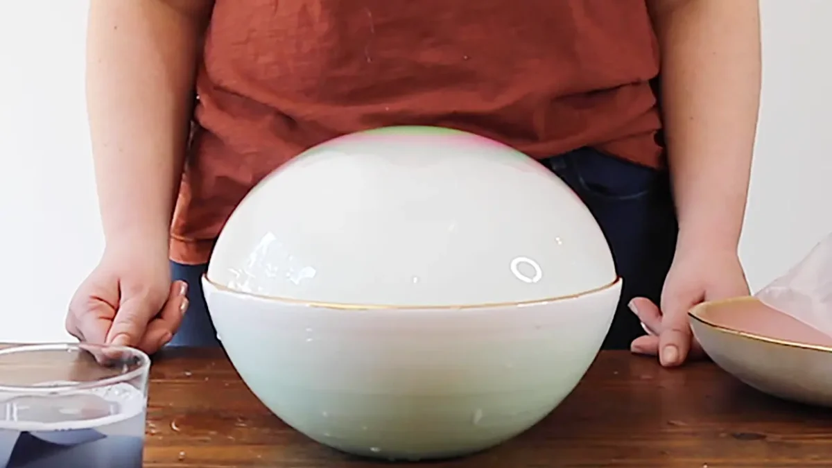 Woman demonstrating a large bubble inside a bowl.