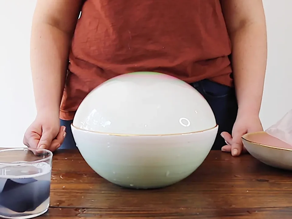 Woman demonstrating a large bubble inside a bowl.