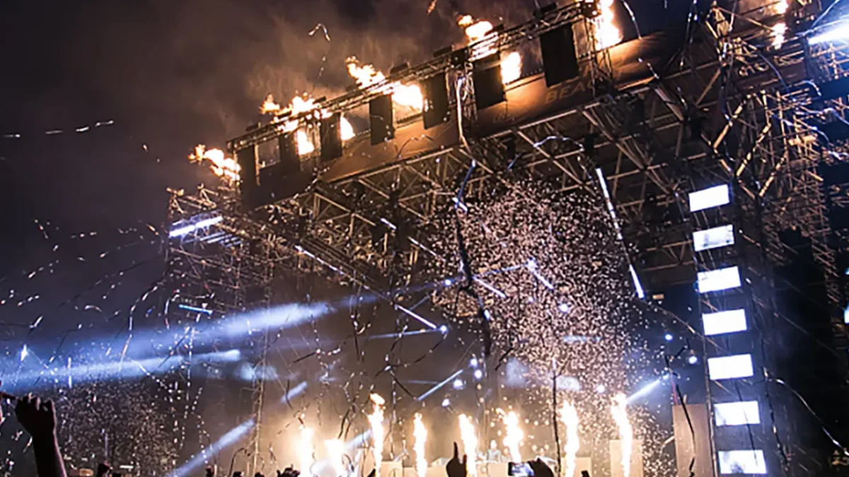Crowd at music festival with pyrotechnics and confetti