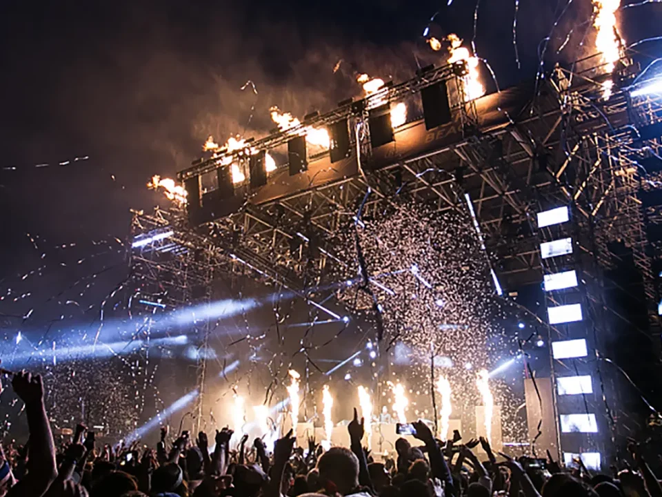 Crowd at music festival with pyrotechnics and confetti