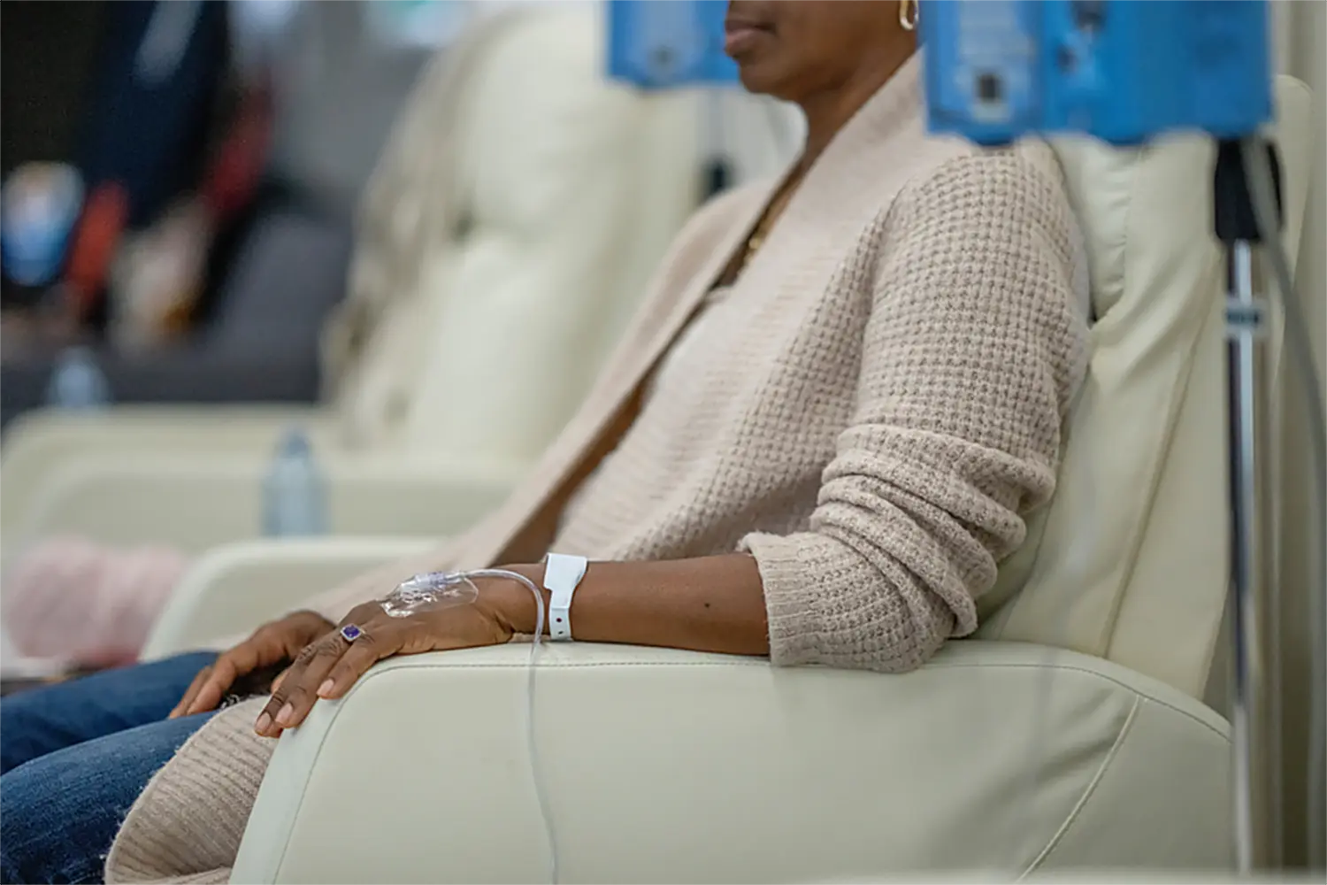 Woman receiving IV hydration therapy in a comfortable medical chair.