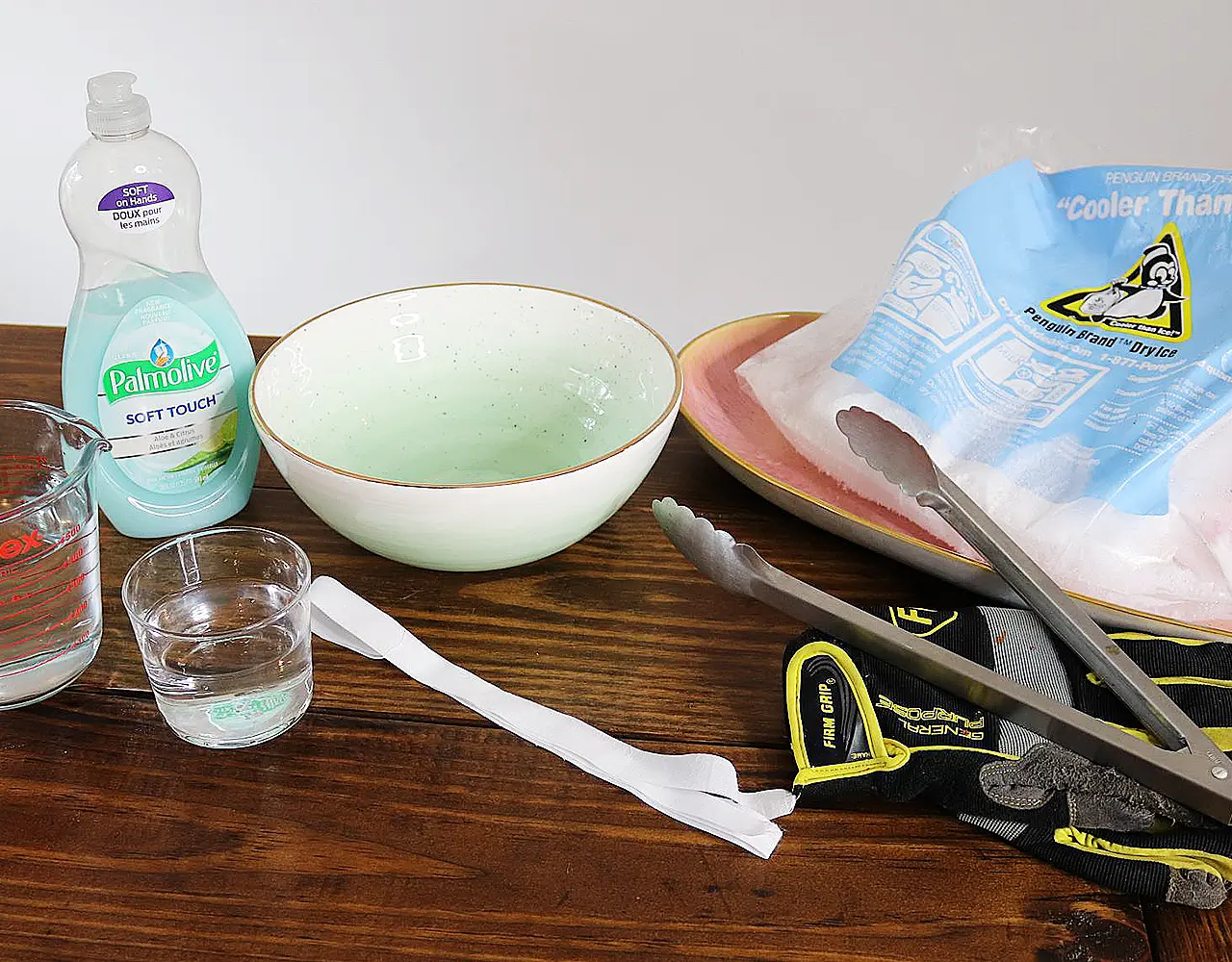 Dry ice experiment supplies: bowl, water, dish soap, tongs, gloves, and dry ice.