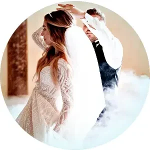 Bride and groom dancing at their wedding reception, surrounded by fog