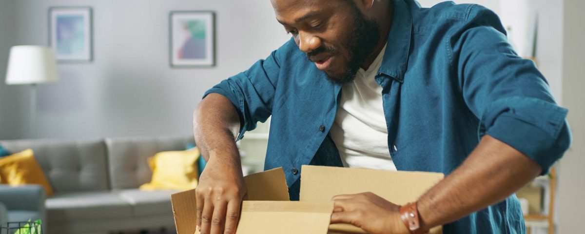 A man closes a package he's preparing to send.